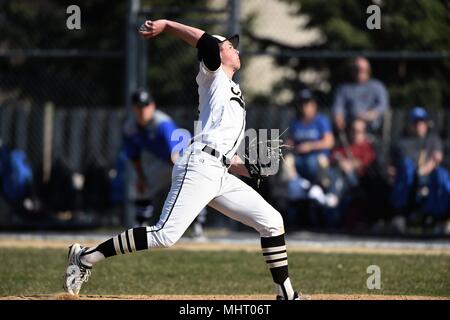 Pitcher delivering a pitch to an opposing hitter during a high school baseball game. USA. Stock Photo