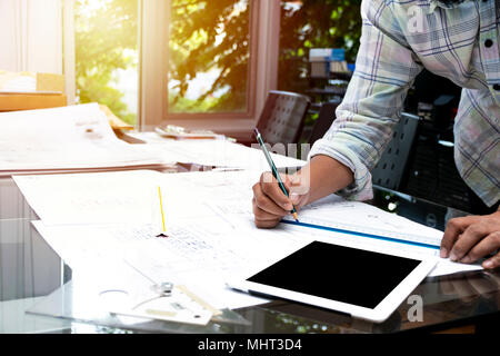 Architects workplace, architectural project,blueprints,ruler.Concept architects.he holding pen pointing equipment architects On the desk with a bluepr Stock Photo