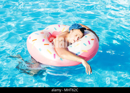 drunk a Russian tourist on an inflatable donut swimming in the pool. Stock Photo