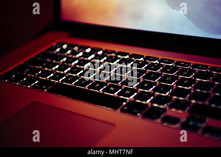 Laptop screen and keyboard glowing in a design studio Stock Photo