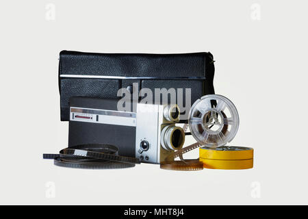 8mm film camera with its genuine black bag one reel in vertical position and two reels in their yellow holder.Film strips between the reels Stock Photo