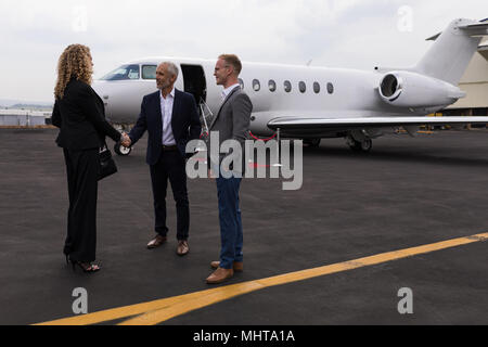 Business people interacting with each other at terminal Stock Photo