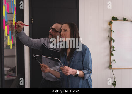Business colleagues writing on sticky notes Stock Photo