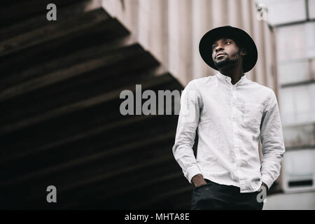 Close up shot of handsome young African American traveler having nice walk in old town during summer vacations. Stock Photo