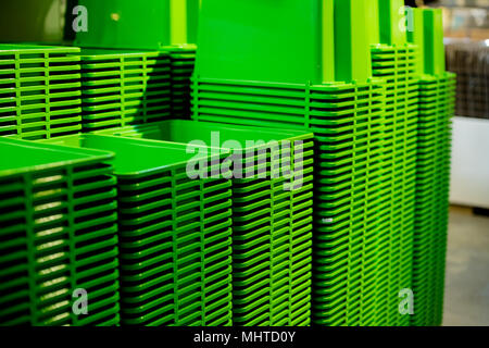 Background texture of green plastic buckets.A stack of recycled plastic buckets on display at a sundry store.bowls on the shelf in the store. Stock Photo