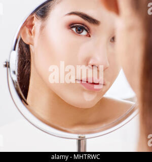 Beautiful woman with vitiligo looking in the mirror. Stock Photo