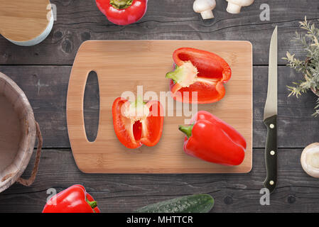 Chopped peppers on the cutting board on kitchen table. Kitchen knife, spices and food beside. Stock Photo