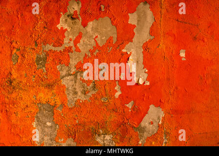 Orange color painted on concrete wall are peeling. Old and dirty wall texture background with space. Stock Photo