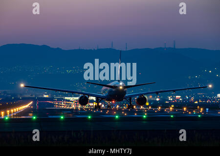 OSAKA, JAPAN - Apr. 28, 2018: Boeing 777-200 taking off from the Itami International Airport in Osaka, Japan at dusk. Stock Photo