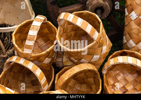 Brown wooden baskets made of a bast in a pile on the ground. Rural fair, vintage goods for sale Stock Photo