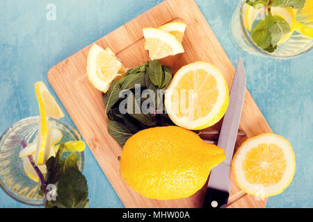 Top view of fresh cut lemons next to two glasses with lemonade Stock Photo