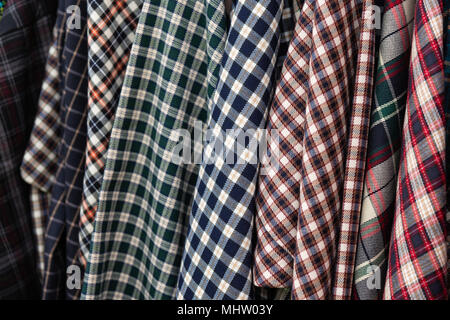 Details of a check or lumberjack flannel shirts which hang in a row Stock Photo