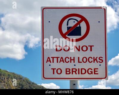 A warning sign informing people not to attach padlocks to a road bridge Stock Photo
