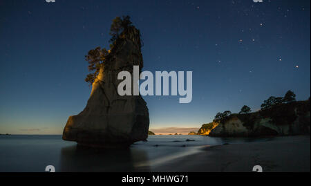 Daybreak at Cathedral Cove, Coromandel peninsula,  with Te Hoho rock in the foreground with stars still showing. Stock Photo