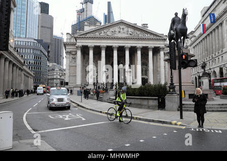 Cyclist waiting at traffic lights on Threadneedle Street with a view of the Royal Exchange outside Bank of England in London UK  KATHY DEWITT Stock Photo
