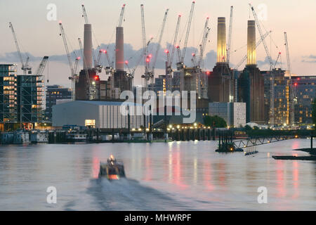 Large construction cranes surround Battersea Power Station on the south bank of the River Thames in West London where a major regeneration project on 