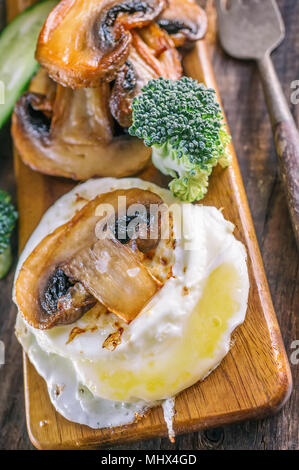 Breakfast eggs Benedict poached egg with pan-fried mushrooms and vegetables. Close up. Selective focus. Stock Photo