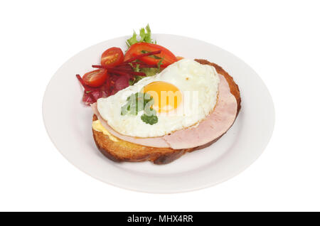 Fried egg and ham on toasted rustic bread with salad on a plate isolated against white Stock Photo