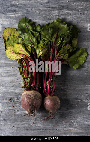 high angle view of some raw beetroots on a rustic gray wooden table Stock Photo