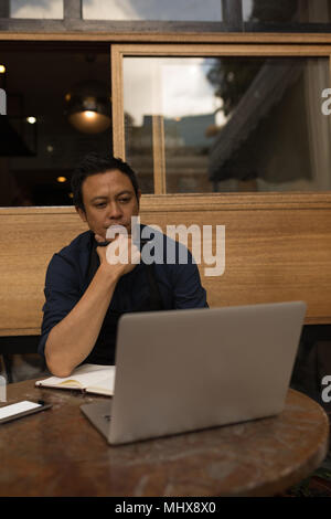 Thoughtful businessman looking at laptop