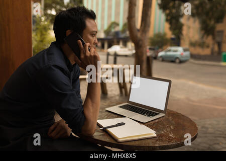 Businessman talking on mobile phone in the cafe Stock Photo