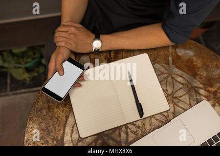 Businessman using mobile phone in cafe Stock Photo