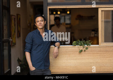 Businessman standing near window in the cafe Stock Photo
