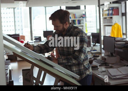 Architect designing on drafting table Stock Photo