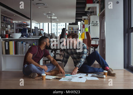 Architects interacting with each other on floor Stock Photo