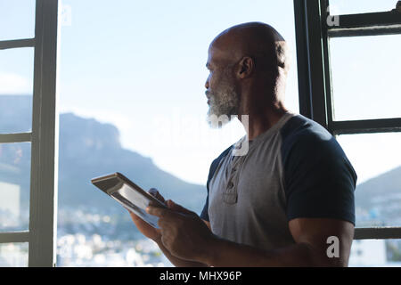 Smiling senior man using digital tablet Stock Photo