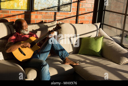 Senior man playing guitar at home Stock Photo
