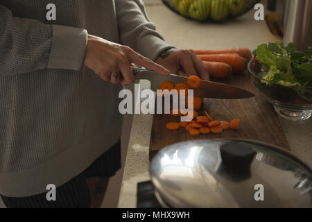 Woman cutting vegetables in kitchen Stock Photo