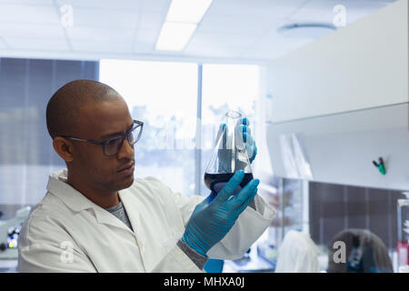 Scientist checking a solution in conical flask Stock Photo