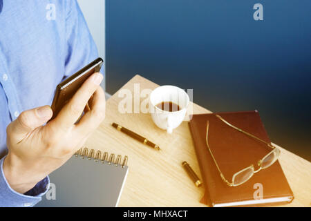 Man reading message on a smartphone. Workplace in the office. Stock Photo
