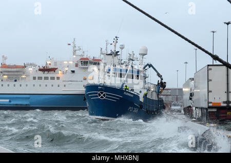 Fishing boat leaving port in a storm on the quay in Lerwick Shetland Stock Photo