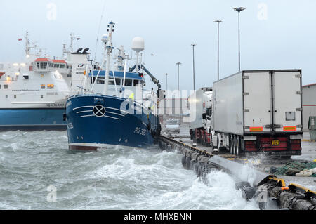 Fishing boat leaving port in a storm on the quay in Lerwick Shetland Stock Photo