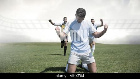 Soccer players celebrating on grass Stock Photo