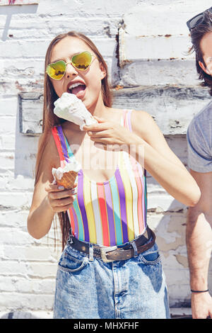 Young women eating melting ice cream cone Stock Photo