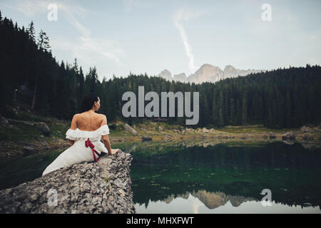 A beautiful married woman in wedding dress, posing for a photo shooting in Italy mountains, Trentino Alto Adige Stock Photo