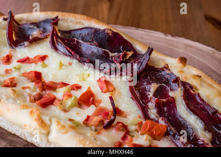 Turkish Pide with Pastirma , tomato and melted cheese on a wooden surface.