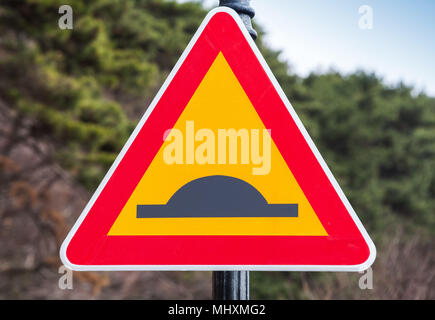 Speed Bump or Uneven Road, yellow triangle warning traffic sign with red frame Stock Photo