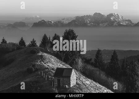 Black and white sunrise on a solitary hut with in the background the dolomite peaks , Pian de le Femene, Veneto, Italy Stock Photo