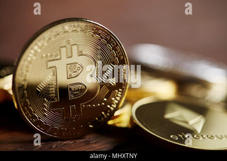 Conceptual image of crypto currency with isolated bitcoins on dark table. Focus of coins. Other in gradient blur. Dark background. Selective focus, fr Stock Photo