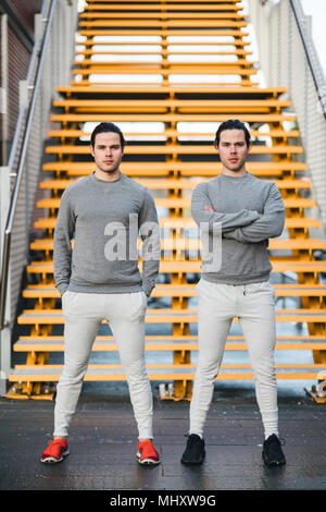 Young adult male twins training together, stairway portrait Stock Photo