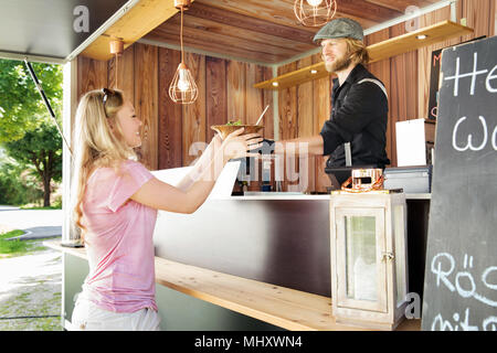 Cook in food truck serving customers, Innsbruck Tirol, Austria Stock Photo