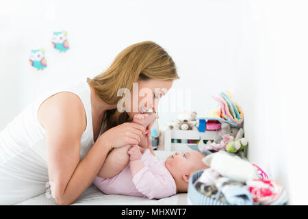 Mother playing with baby on changing table Stock Photo