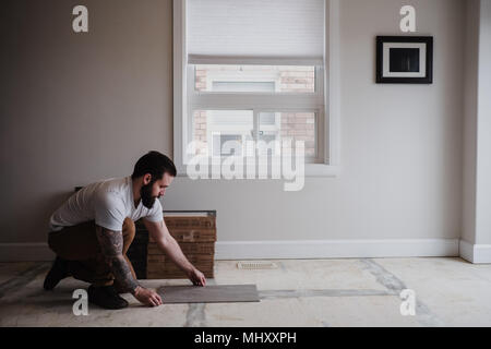 Man installing floor tiles Stock Photo