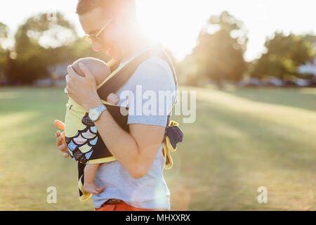 Father carrying baby boy in baby carrier Stock Photo