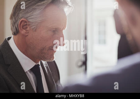 Businessman in office talking to colleague Stock Photo