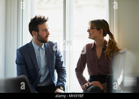 Colleagues chatting in office Stock Photo